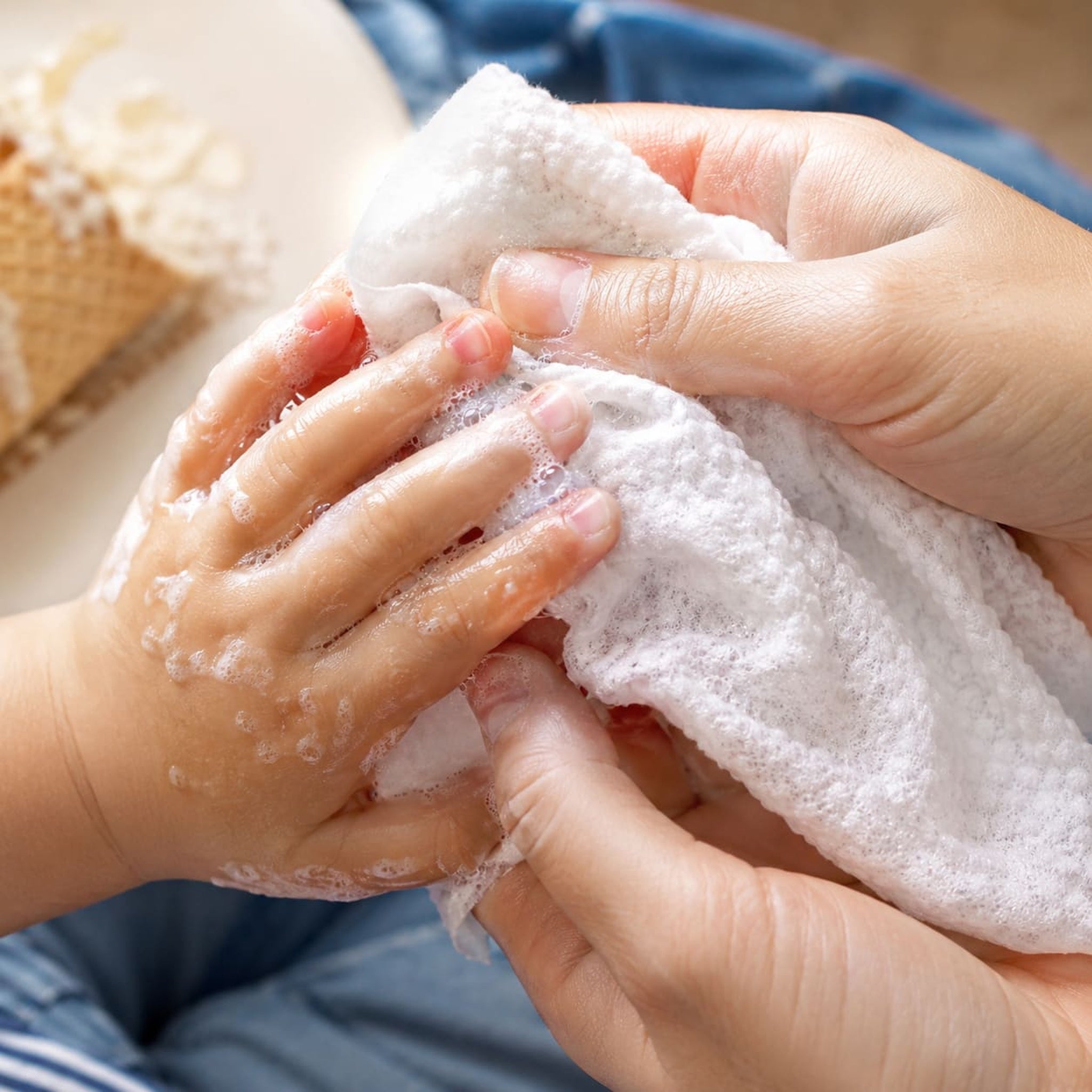 Hands using a Bubbez plant-based WASH wipe