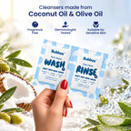 A hand holds an unopened Bubbez WASH and RINSE twin sachet among coconut, olive branches and splashing water. Headline reads Cleansers made from Coconut Oil and Olive Oil, with Fragrance Free, Dermatologist Tested and Suitable for Sensitive Skin icons.