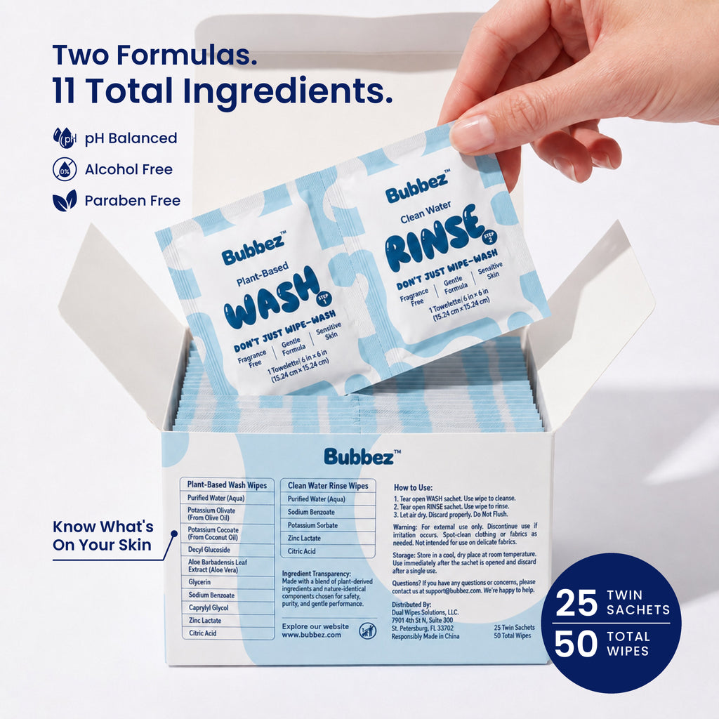 A hand lifts a Bubbez WASH and RINSE twin sachet from an open 25 count box. The box panel lists the full ingredients for both formulas alongside the how to use steps. Headline reads Two Formulas. 11 Total Ingredients, with pH Balanced, Alcohol Free and Paraben Free icons and a 25 twin sachets, 50 total wipes badge.