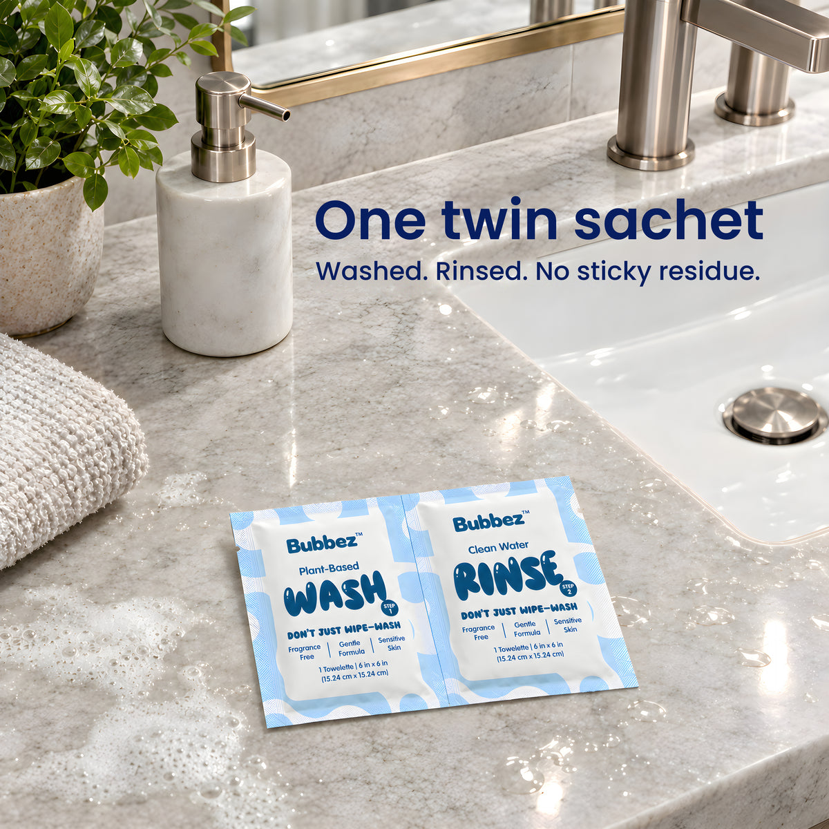 A Bubbez WASH and RINSE twin sachet lies open on a marble bathroom vanity beside the sink, a folded towel and a plant. Headline reads One twin sachet. Washed. Rinsed. No sticky residue.