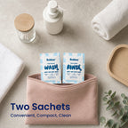 A Bubbez WASH and RINSE twin sachet tucked into a pink cosmetic pouch on a stone vanity with rolled towels, a pump bottle, cotton buds and eucalyptus. Headline reads Two Sachets. Convenient, Compact, Clean.