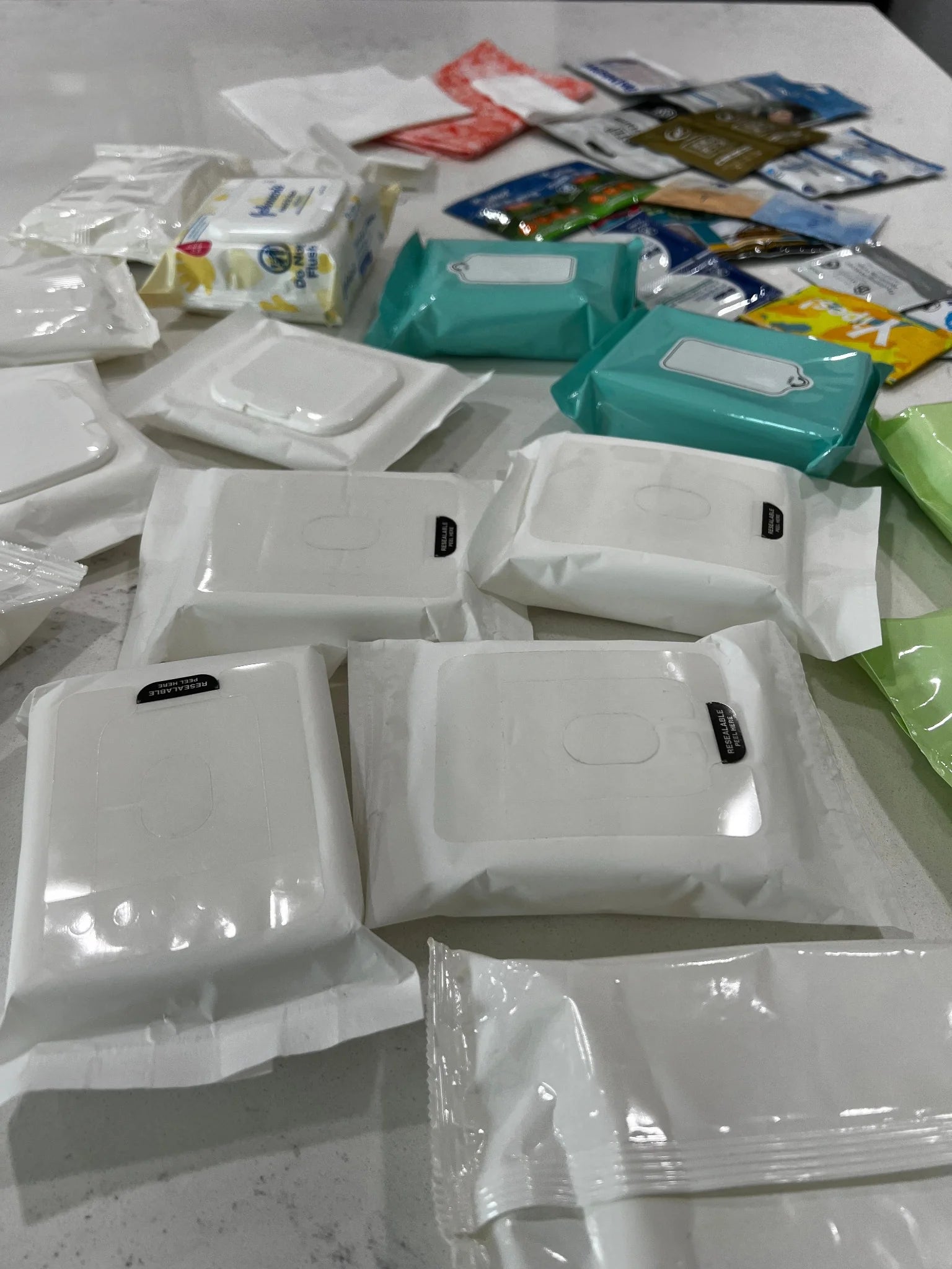 Assorted personal care products including wipes and containers on a light surface.