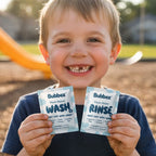 Child holding Bubbez plant-based wash and rinse packets outdoors