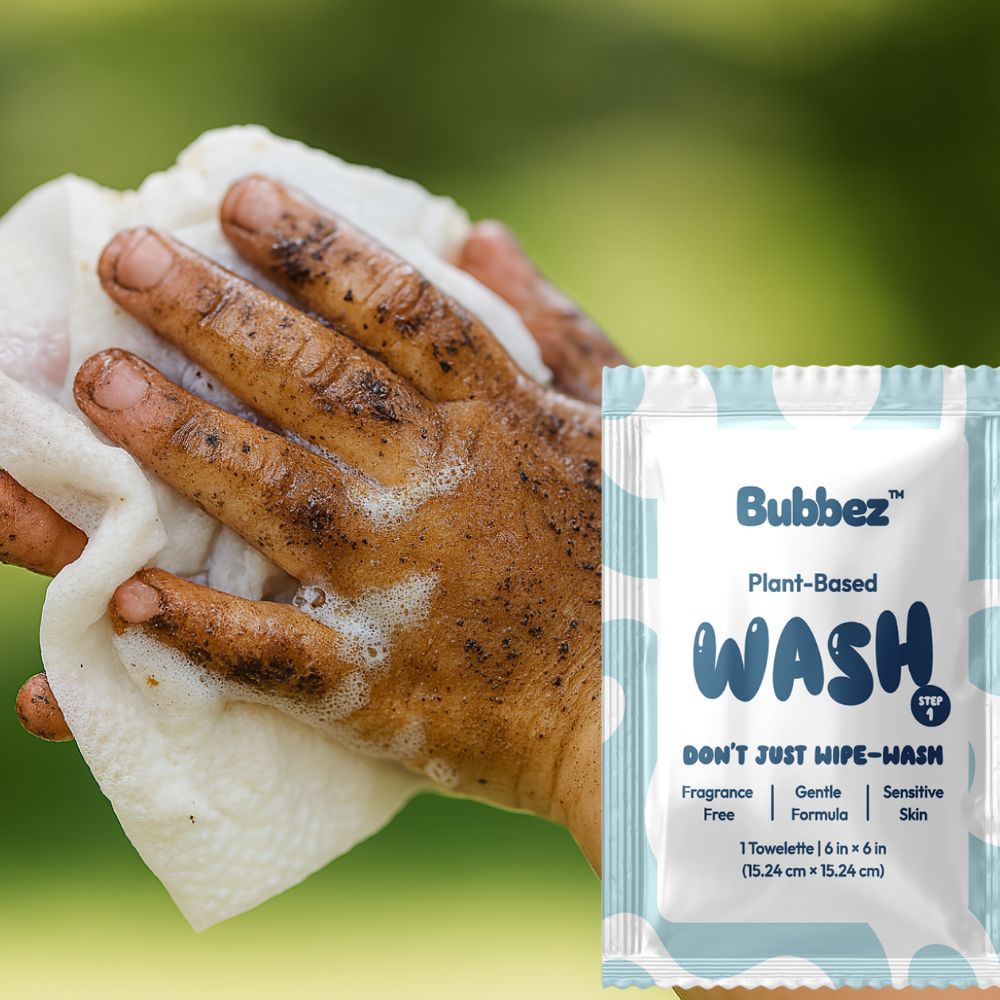 Hand holding a soapy towel with Bubbez Plant-Based Wash packaging on a green background